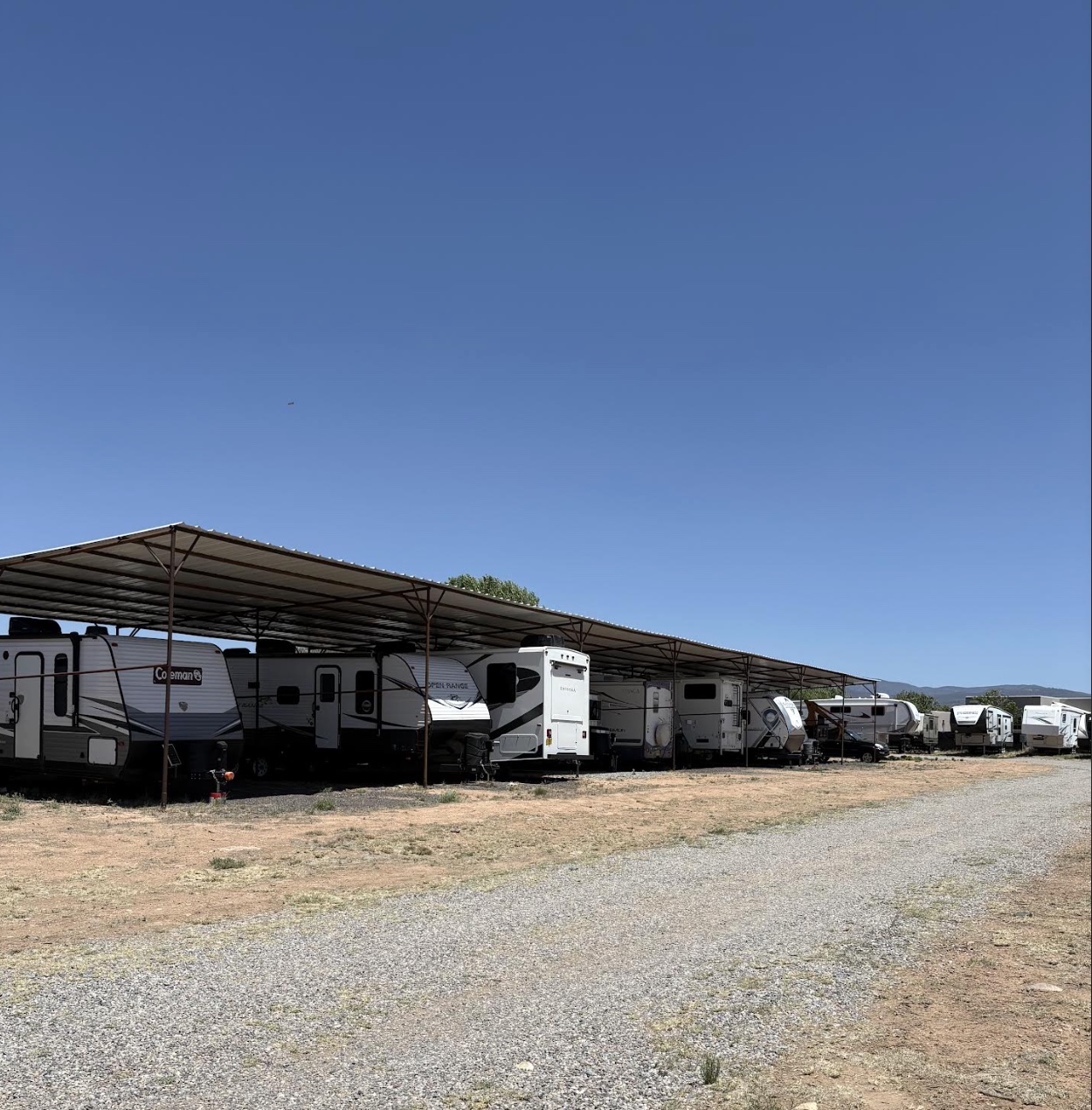 A full row of trailers parked under the covered shade structure.